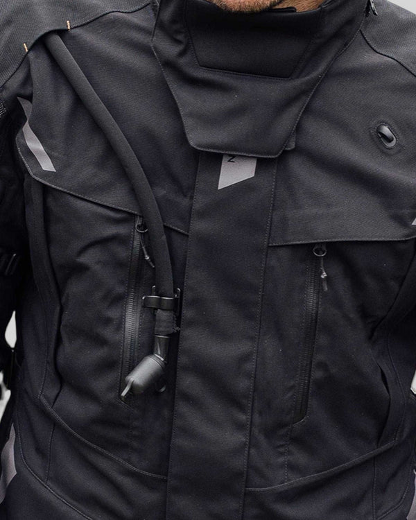 Baffle Haus Akashi 2.5l hydration bladder tube attached to a black motorcycle laminate jacket