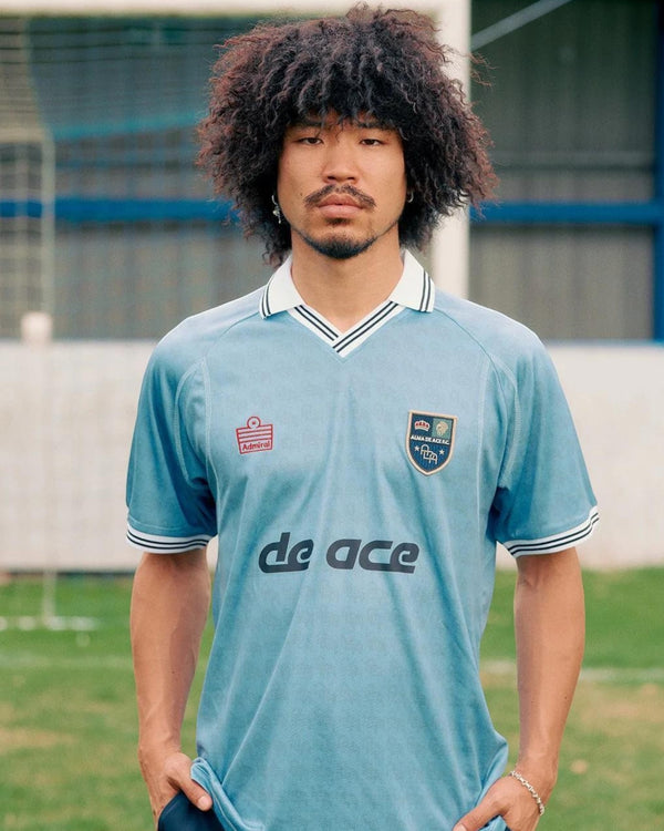 Baffle Haus Alma De Ace F.C. light blue football away top with white collar and vintage-inspired design on a model