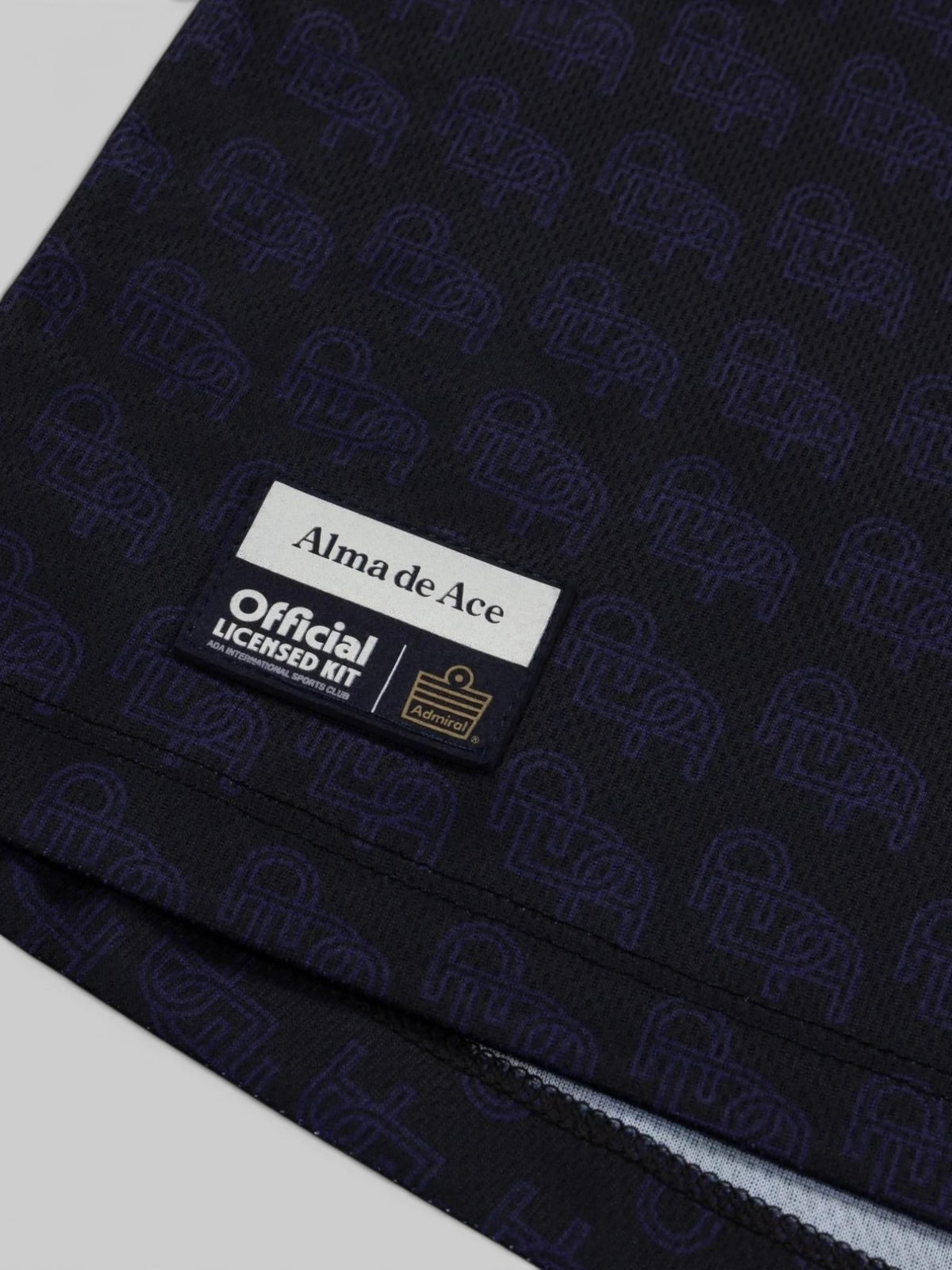 Baffle Haus Alma De Ace navy blue football top with repeating logo pattern and official licensed kit patch