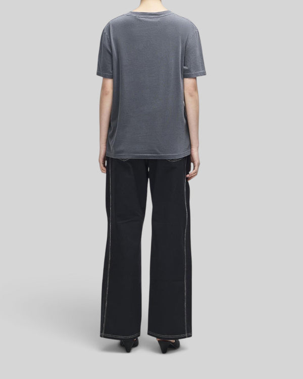 Back view of a woman wearing a Baffle Haus anthracite grey lightweight classic fit tee with a soft wash finish.