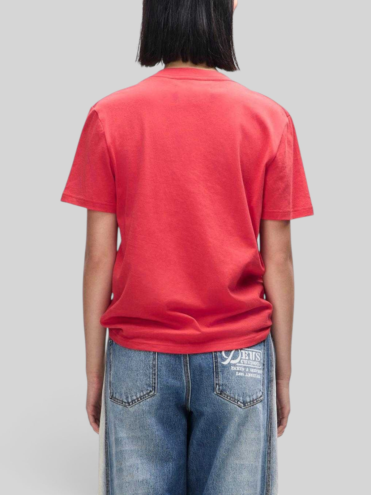 Baffle Haus Bird Scratch Tee in Poinsettia Red, a lightweight classic fit t-shirt worn from the back view.