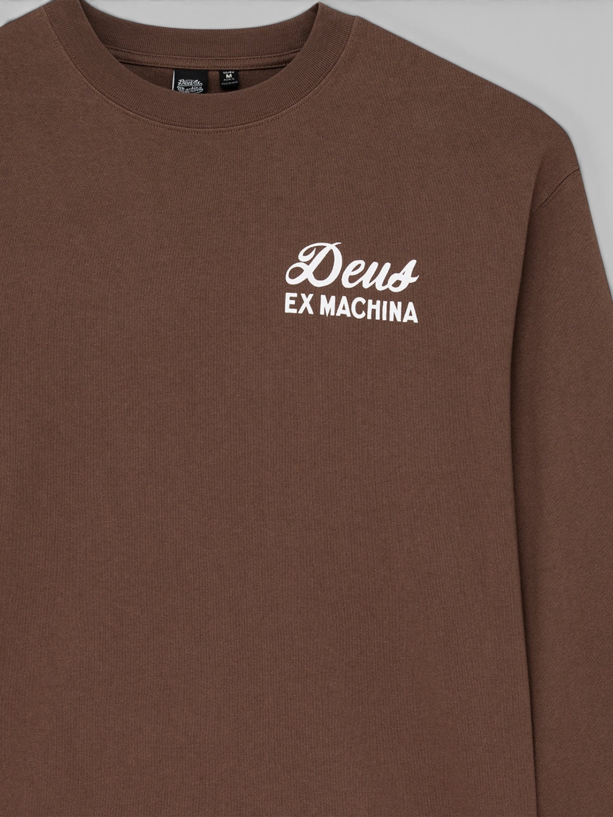 Baffle Haus Harajuku long sleeve tee in bison brown recycled cotton with white Deus Ex Machina chest logo print