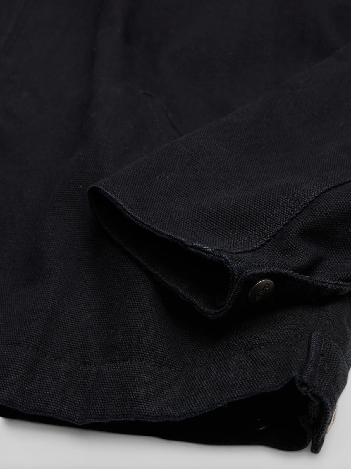 Baffle Haus black cotton canvas workwear jacket sleeve with metal branded snap cuff adjuster