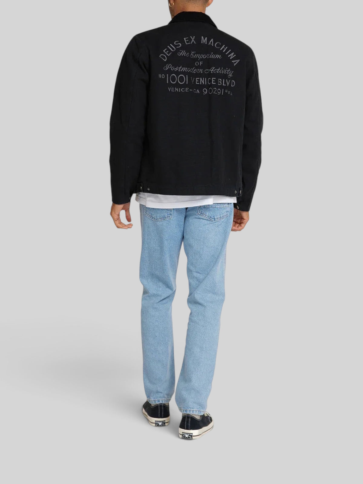 Baffle Haus black cotton canvas workwear jacket with embroidered address on back, worn by a model from behind.