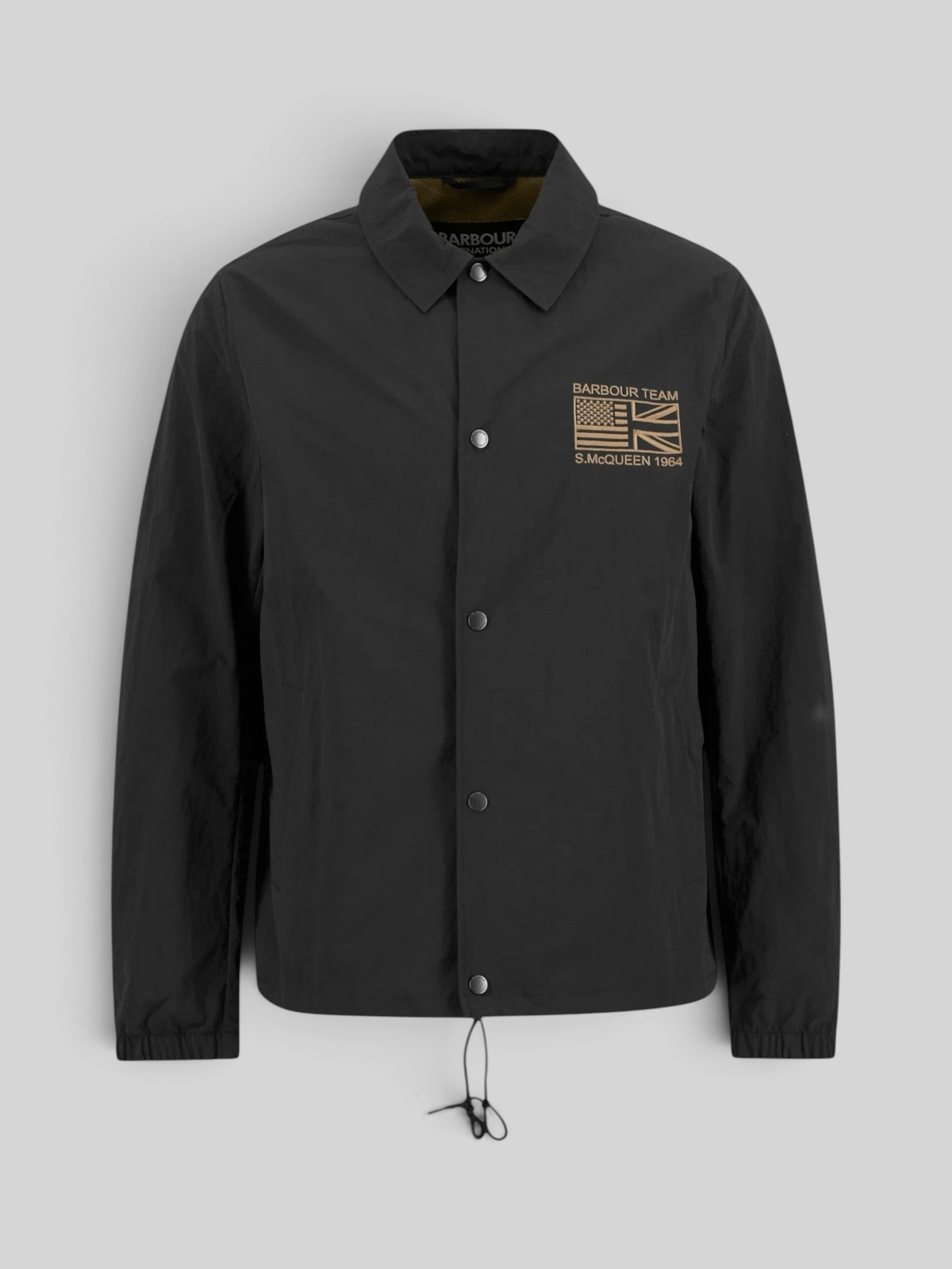 Baffle Haus black casual coach jacket with stud front, sit-down collar, drawcord hem, and Steve McQueen embroidery.