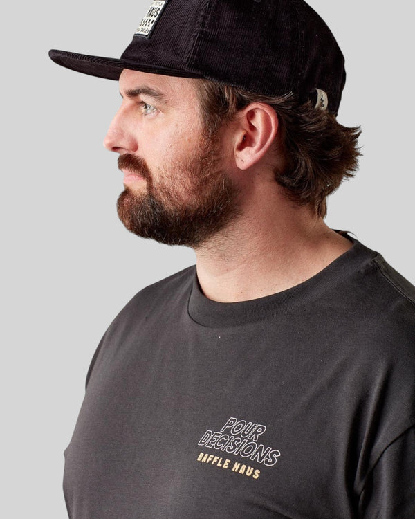 Man wearing a black Baffle Haus corduroy panel cap with a structured fit and textured finish, side profile view.