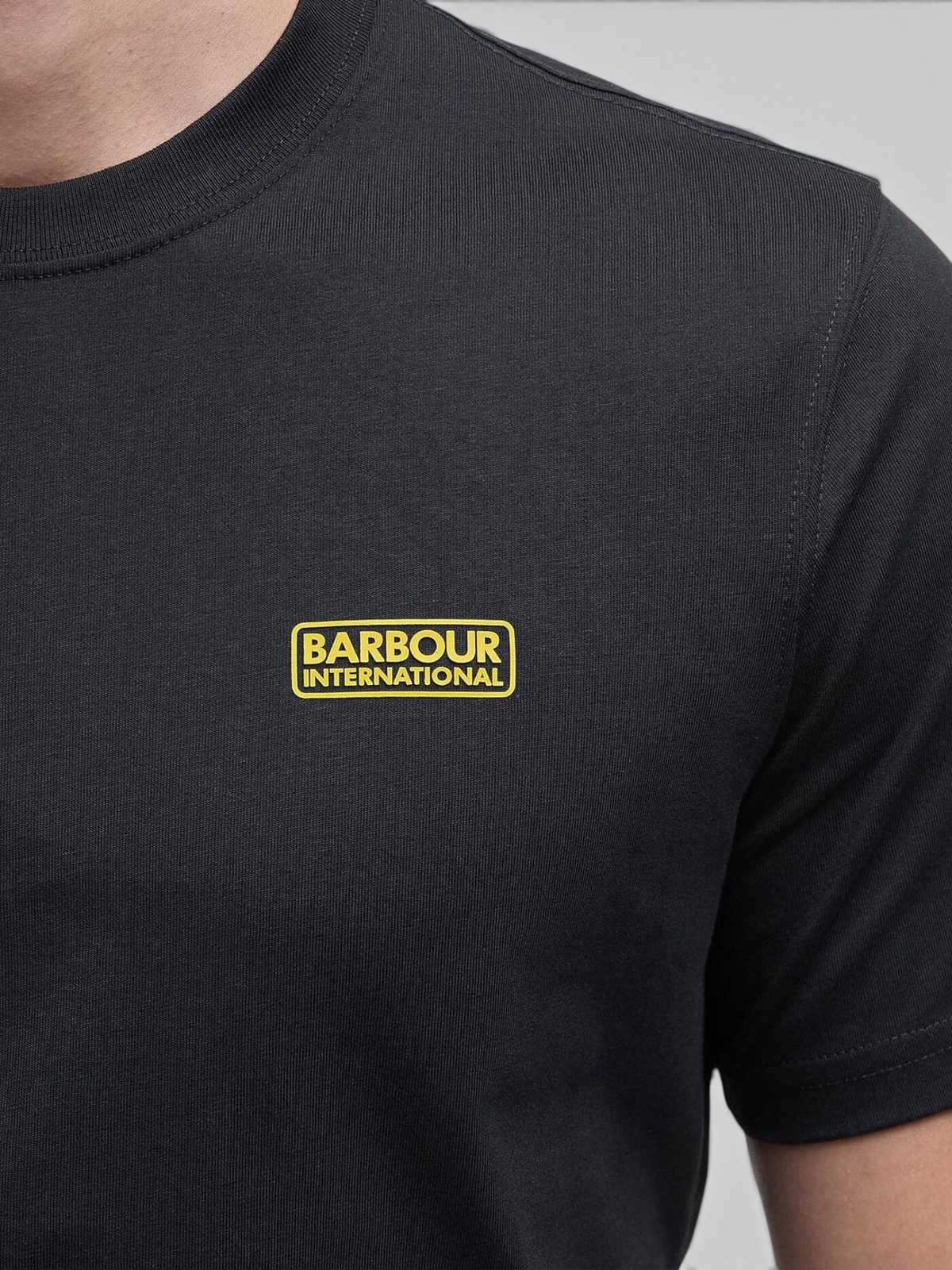 Baffle Haus black cotton crew neck T-shirt featuring a yellow Barbour International logo on the chest