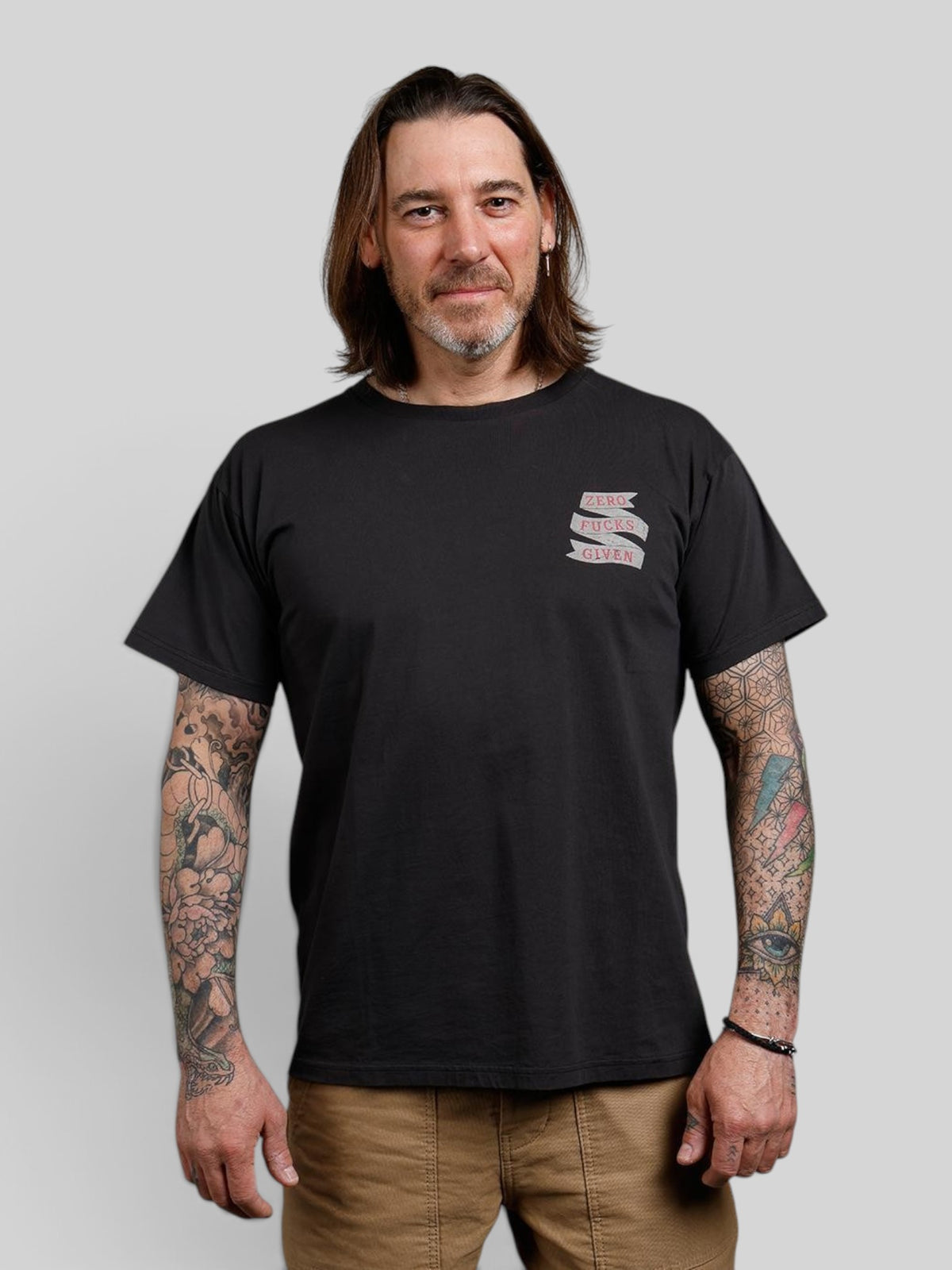 Baffle Haus black 100% cotton sports tee with Zero F***S graphic on chest worn by a tattooed man