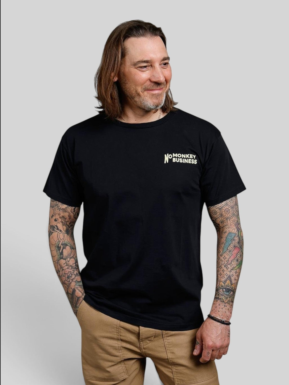 Baffle Haus black 100% cotton sports tee with No Monkey Business chest print worn by a tattooed man