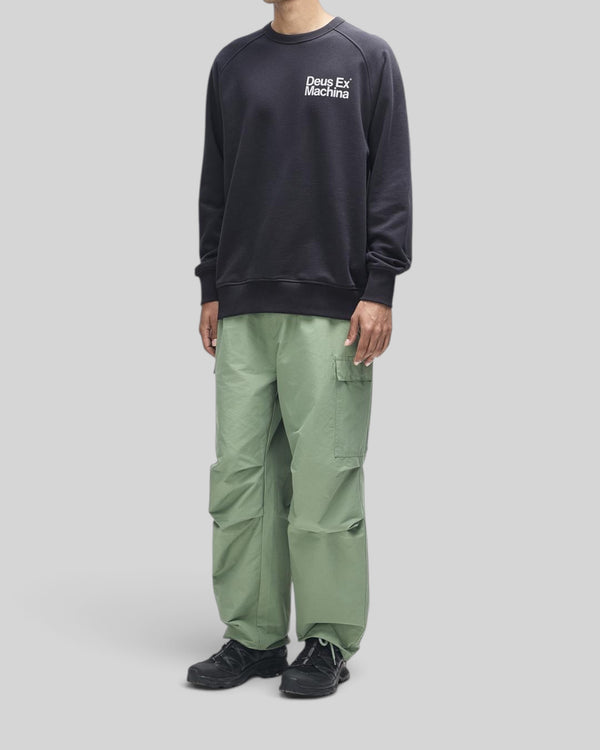 Baffle Haus Plenty Good Crew black fleece with chest print and nylon sleeve panels worn by a model