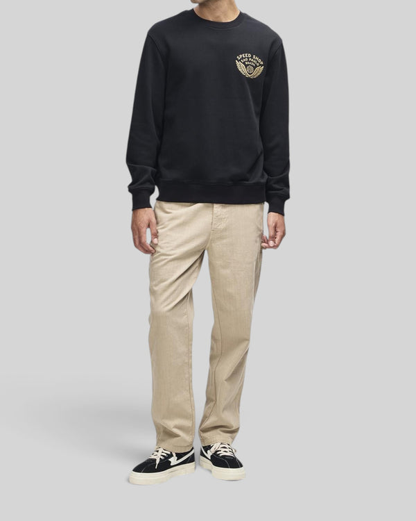 Baffle Haus Munificence crew neck fleece in black with chest graphic, ribbed cuffs, and hem on a male model.