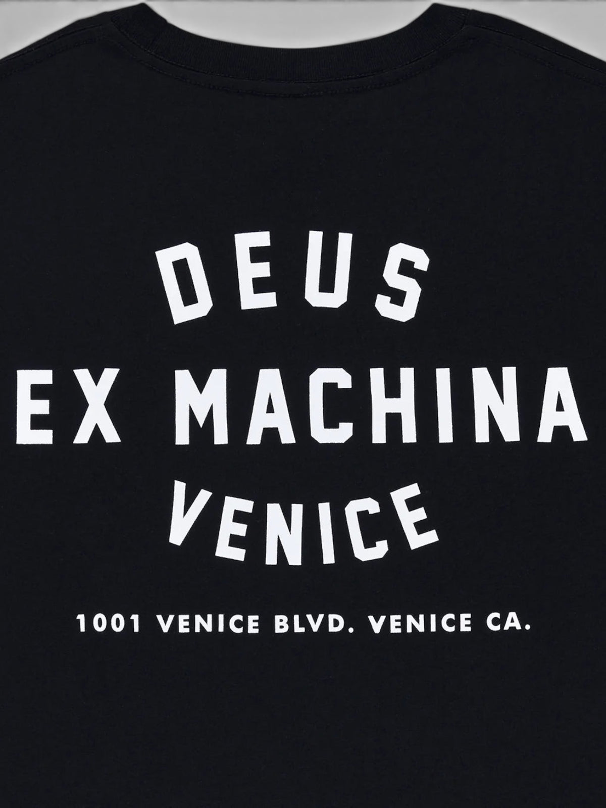 Baffle Haus black organic cotton t-shirt featuring white Deus Ex Machina Venice address graphic on the back