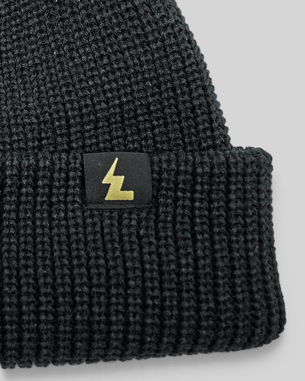 Baffle Haus black fisherman beanie with a ribbed knit texture and a small woven logo label on the cuff.