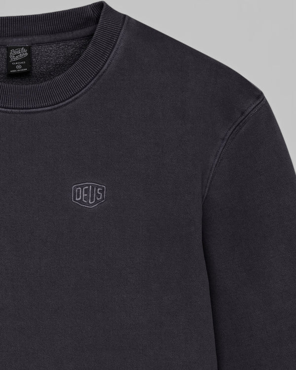 Baffle Haus black garment dyed crew neck sweatshirt with embroidered Deus shield logo on the chest