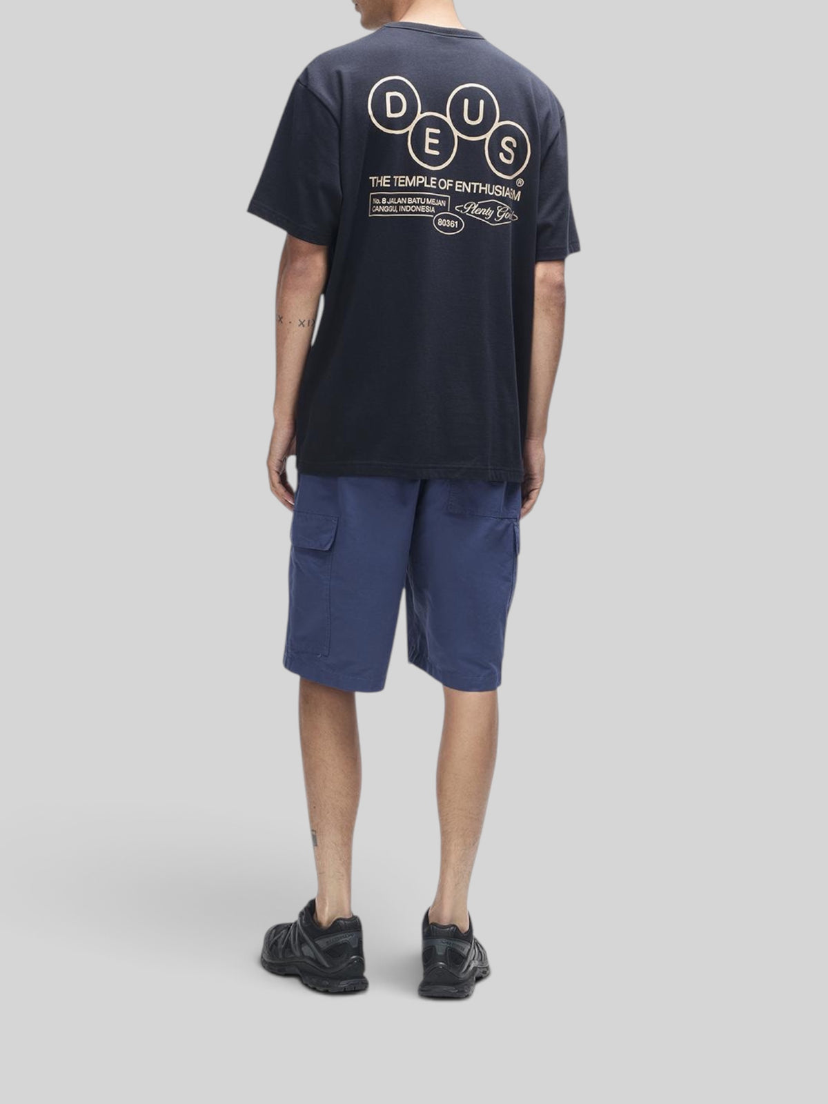 Baffle Haus black short sleeve cotton t-shirt with graphic print on back worn with blue cargo shorts