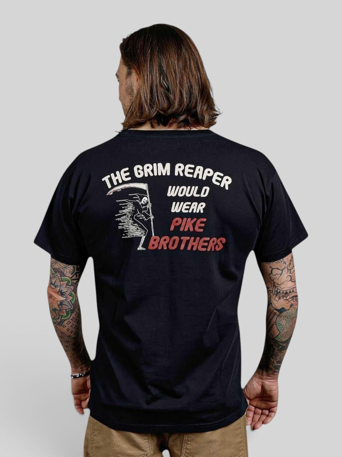 Baffle Haus black 100% cotton sports tee with a vintage Grim Reaper graphic print on the back worn by a man