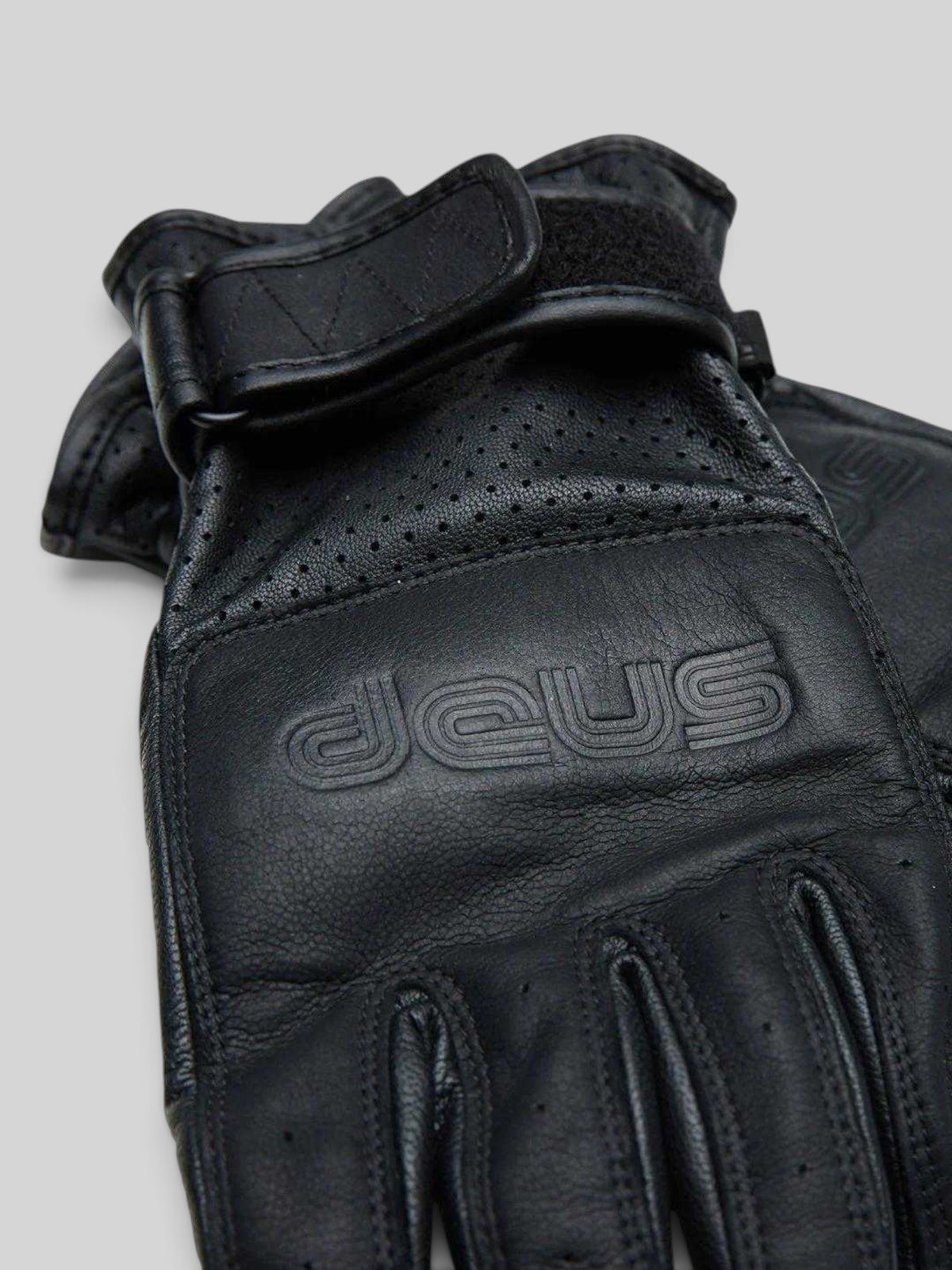 Baffle Haus black goat nappa leather riding gloves with embossed logo, perforated panels, and velcro wrist strap.