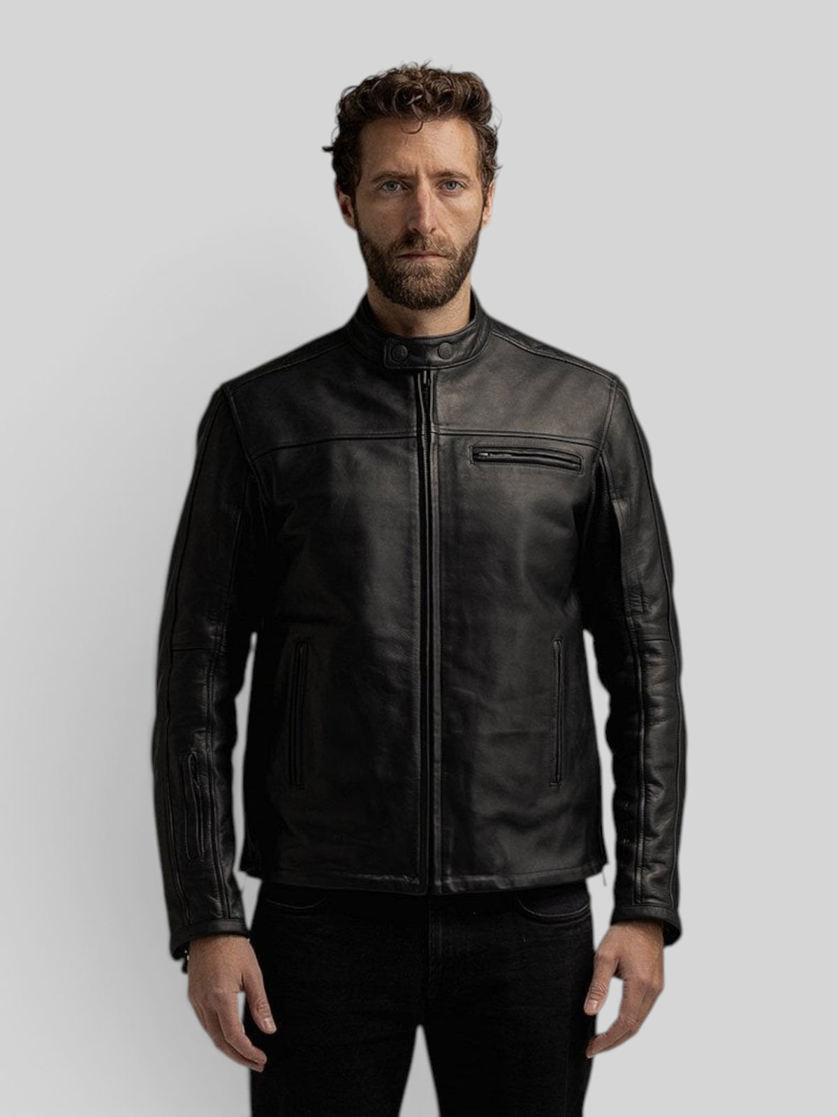 A man wearing a Baffle Haus black cowhide leather riding jacket with a mandarin collar and zippered pockets.