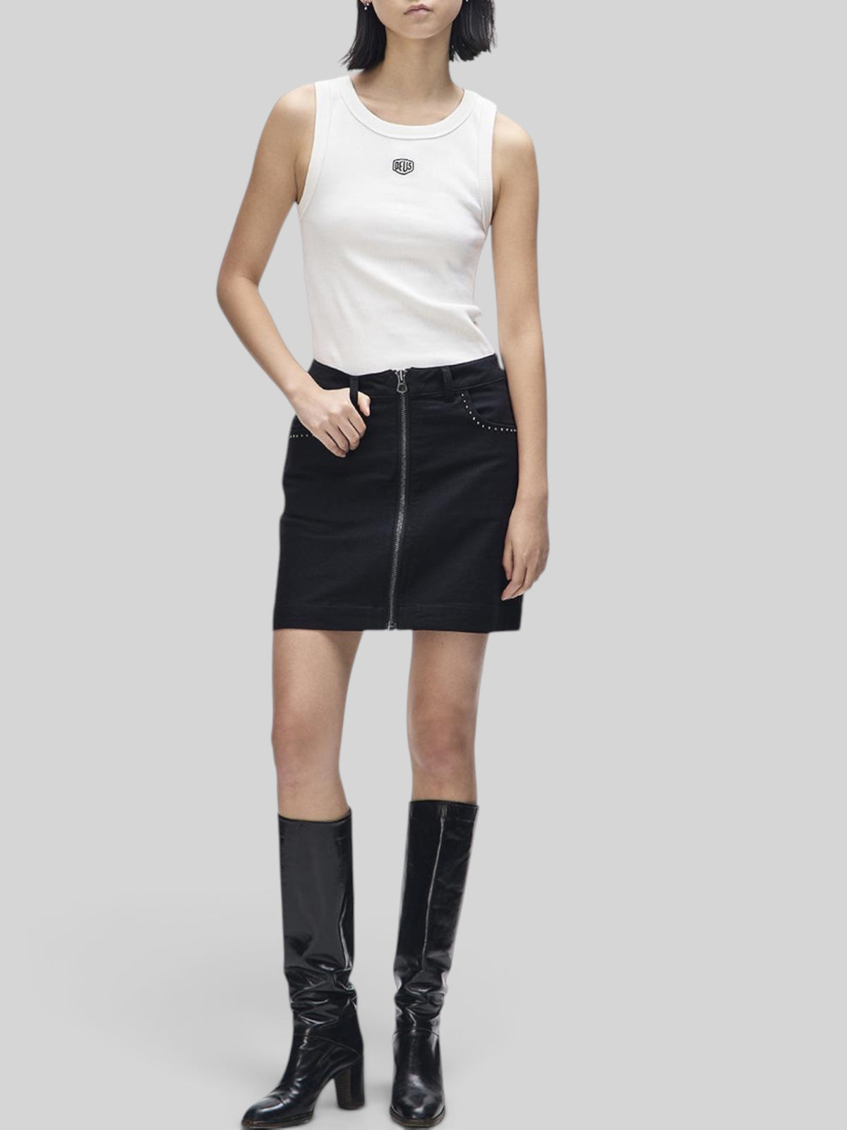 Baffle Haus Outlaw black cotton moleskin mini skirt with front zip and studded pocket detail worn by a model