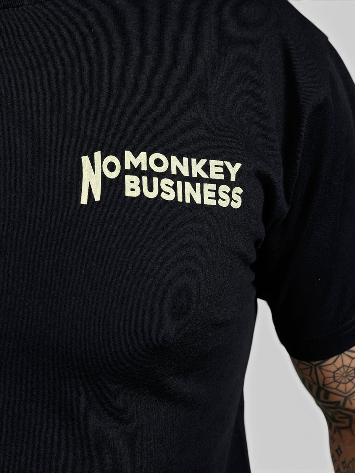Baffle Haus black 100% cotton sports tee featuring a cream No Monkey Business chest print in a 1960s style.