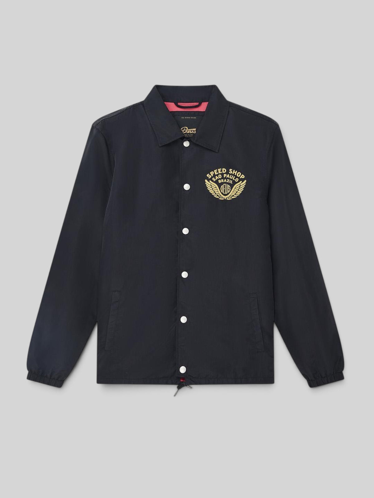 Baffle Haus Munificence black nylon coach jacket with gold graphic print on chest and snap button closure