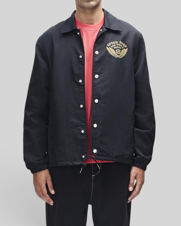 Baffle Haus Munificence black recycled nylon coach jacket with gold chest graphic and snap button closure