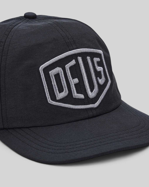 Baffle Haus black nylon unstructured mid crown cap with a grey embroidered shield patch on the front