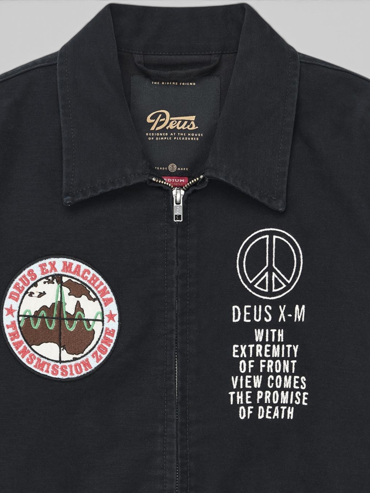 Baffle Haus black souvenir jacket featuring embroidered Deus Ex Machina patches and graphic text on the chest