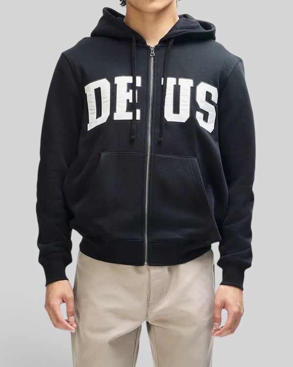 Baffle Haus black zip-up hoodie with white chest appliqué, drawstring hood, and ribbed cuffs on a male model