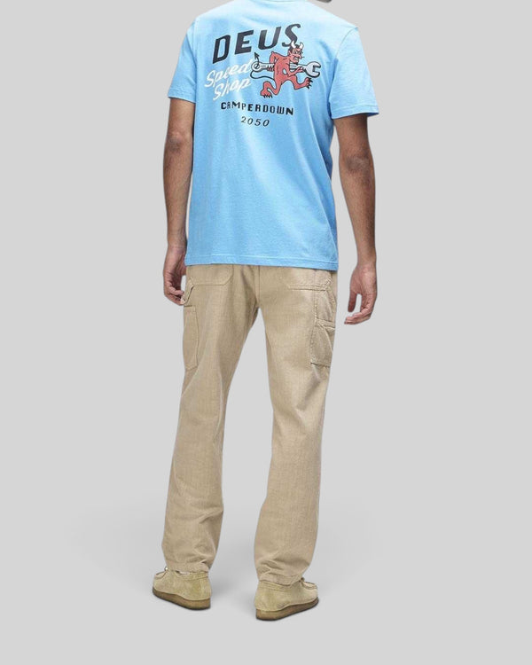 Baffle Haus model wearing a Bonnie Blue Deus short sleeve tee with back graphic print and beige utility trousers.