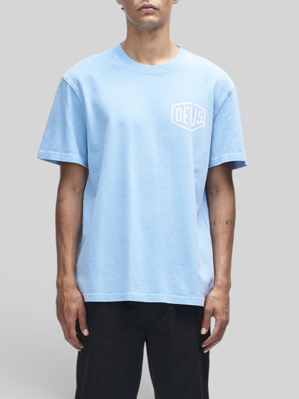 Baffle Haus model wearing a Bonnie Blue heavyweight recycled cotton box fit t-shirt with Deus shield chest graphic