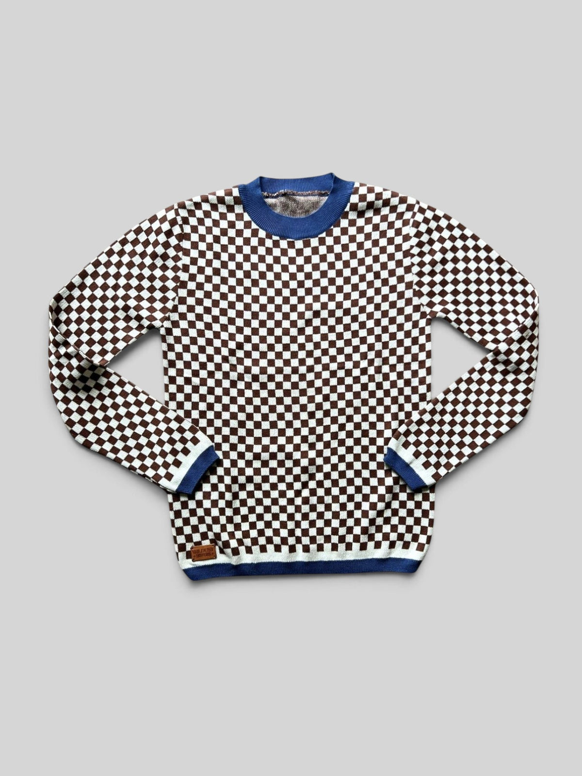 Baffle Haus vintage racing jumper in a brown and white checkerboard knit pattern with blue ribbed collar and cuffs.