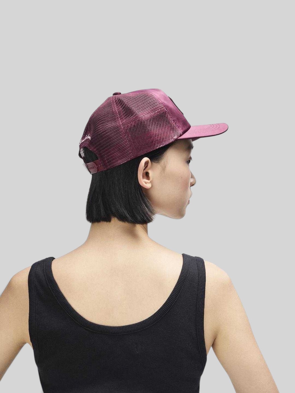 Baffle Haus Paris Shield trucker cap in cabernet red satin and mesh with a snapback closure, worn by a model.