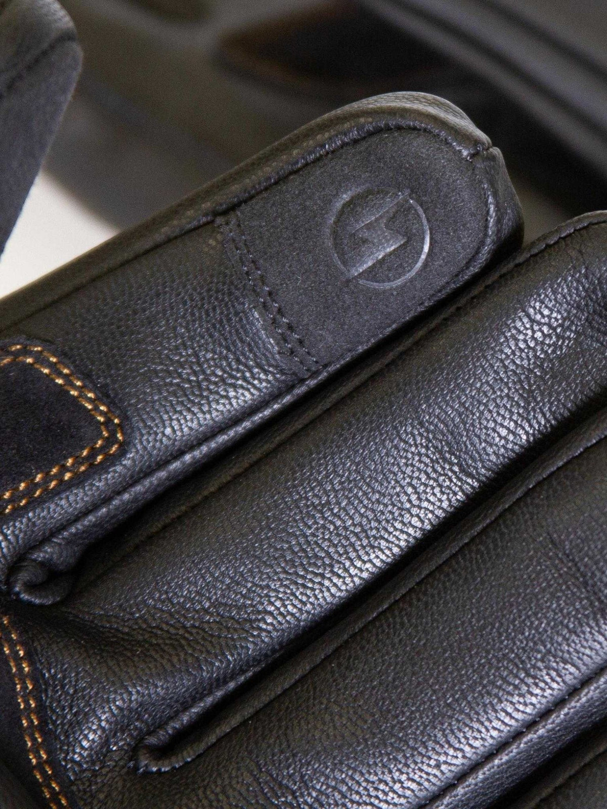 Baffle Haus Calton black leather motorcycle glove featuring textured cowhide, contrast stitching, and finger detail.