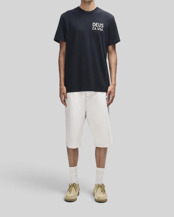 Baffle Haus Camber Tee in black with white chest print, worn by a model in a regular fit organic cotton jersey.