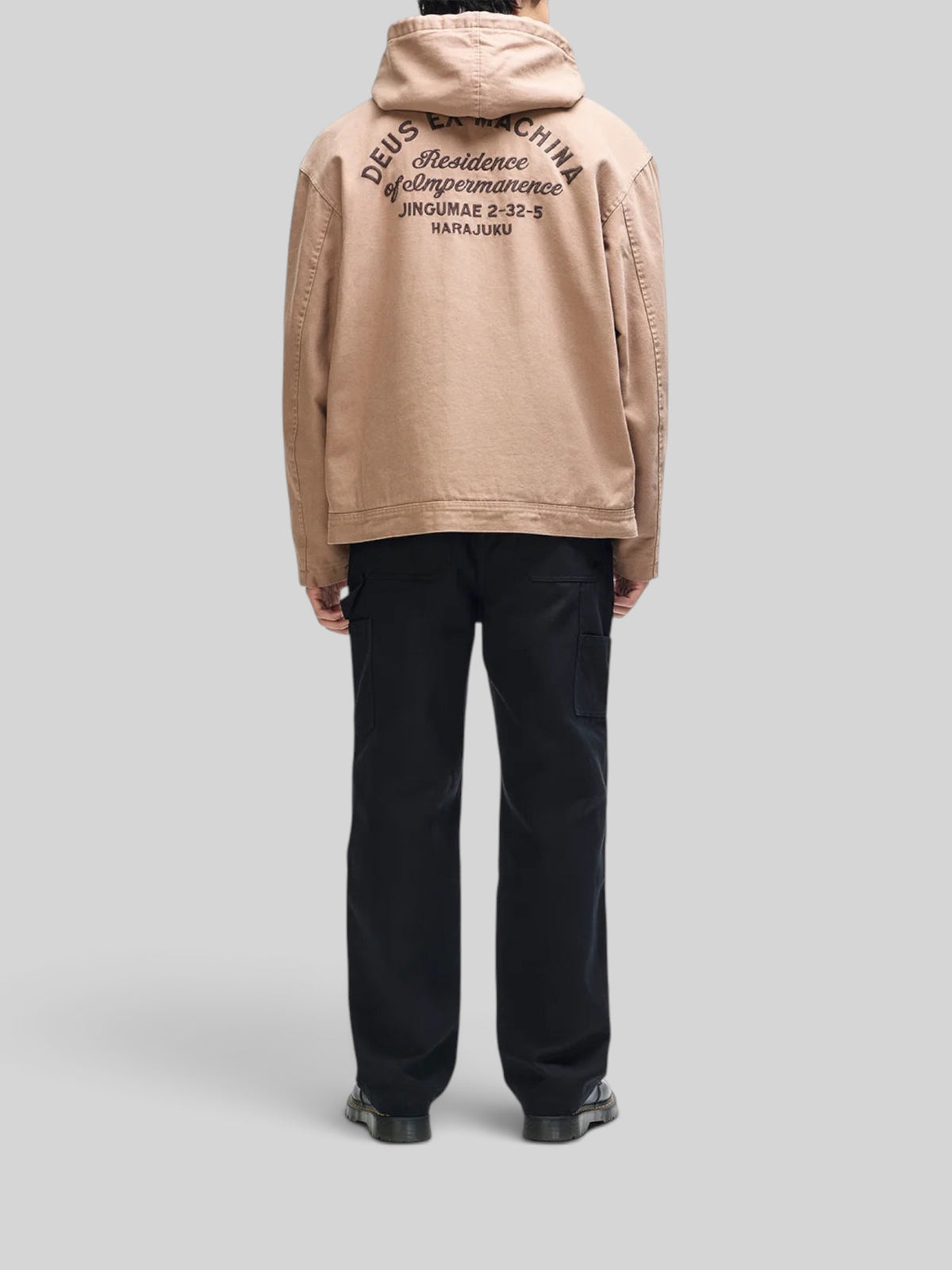 Baffle Haus camel brown cotton canvas hooded work jacket with back embroidery, worn by a model from the back view.