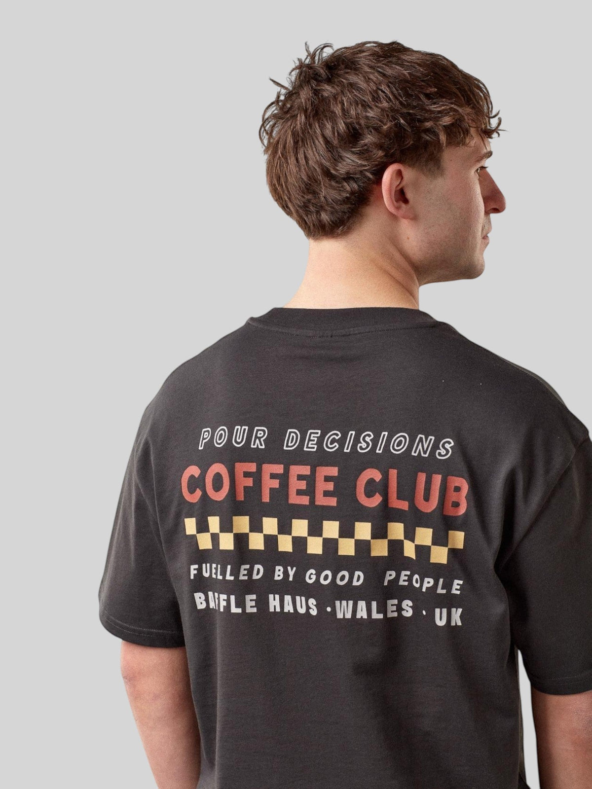 Baffle Haus Pour Decisions Coffee Club t-shirt in carb grey cotton with back graphic print worn by a male model