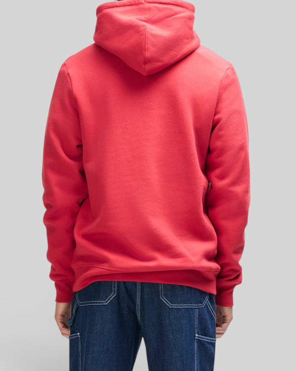 Back view of a person wearing a Baffle Haus cherry red organic cotton brush back fleece hoodie with ribbed cuffs.