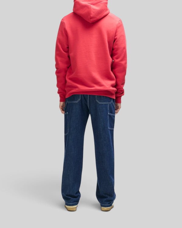 Back view of a person wearing a Baffle Haus cherry red organic cotton fleece hoodie with a boxy fit.