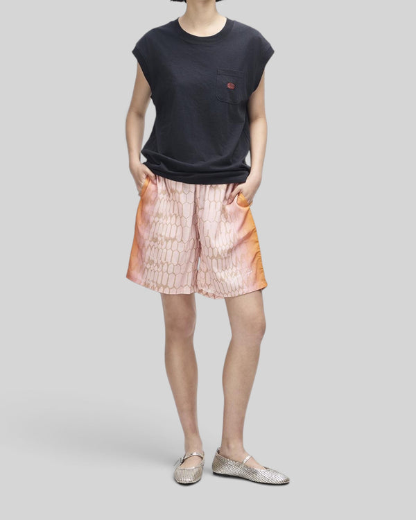 Baffle Haus Christine tank in black with cap sleeves and chest pocket worn with patterned pink shorts