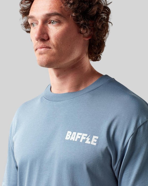 Baffle Haus Flags Tee in coastal blue cotton with white chest logo worn by a male model