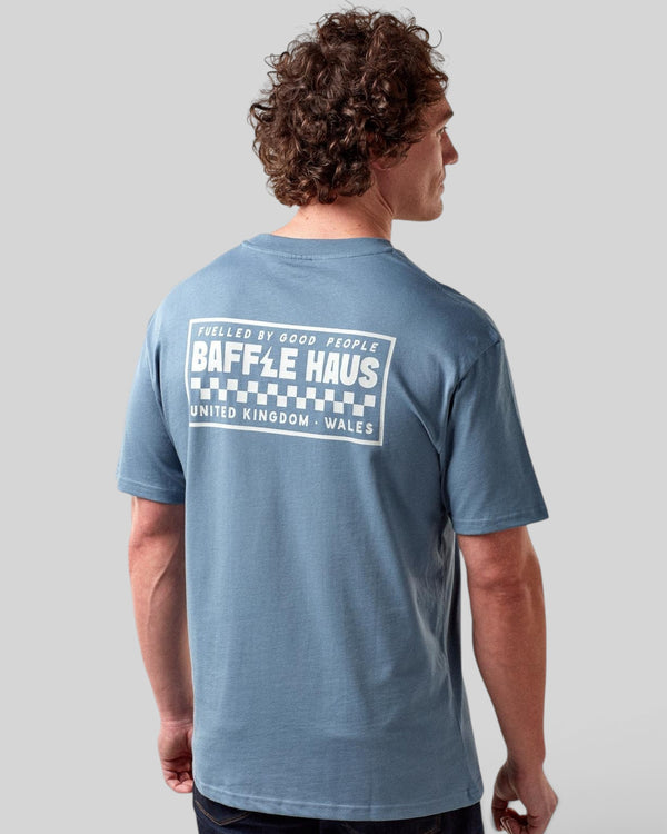 Model wearing a Baffle Haus coastal blue cotton t-shirt with a white graphic print on the back