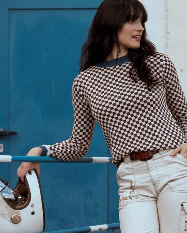 Baffle Haus vintage racing jumper in coffee brown and beige checkerboard cotton knit worn by a woman with a helmet.