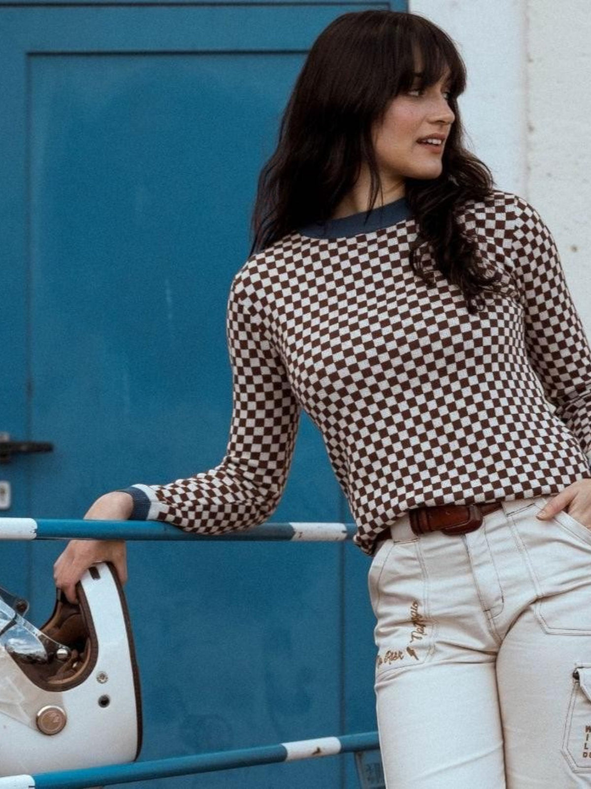 Baffle Haus vintage racing jumper in coffee brown and beige checkerboard cotton knit worn by a woman with a helmet.