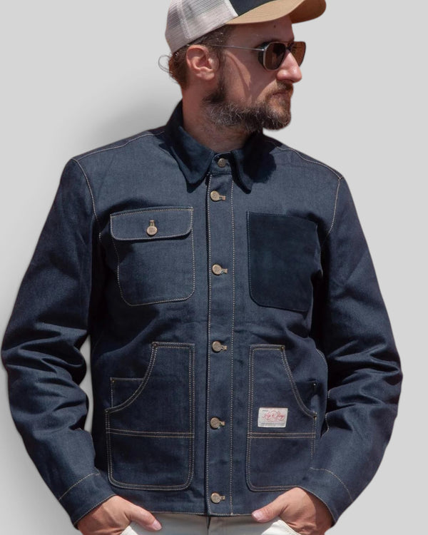 Baffle Haus Age Of Glory Craftsman denim jacket with antique brass buttons and protective pockets on a bearded man