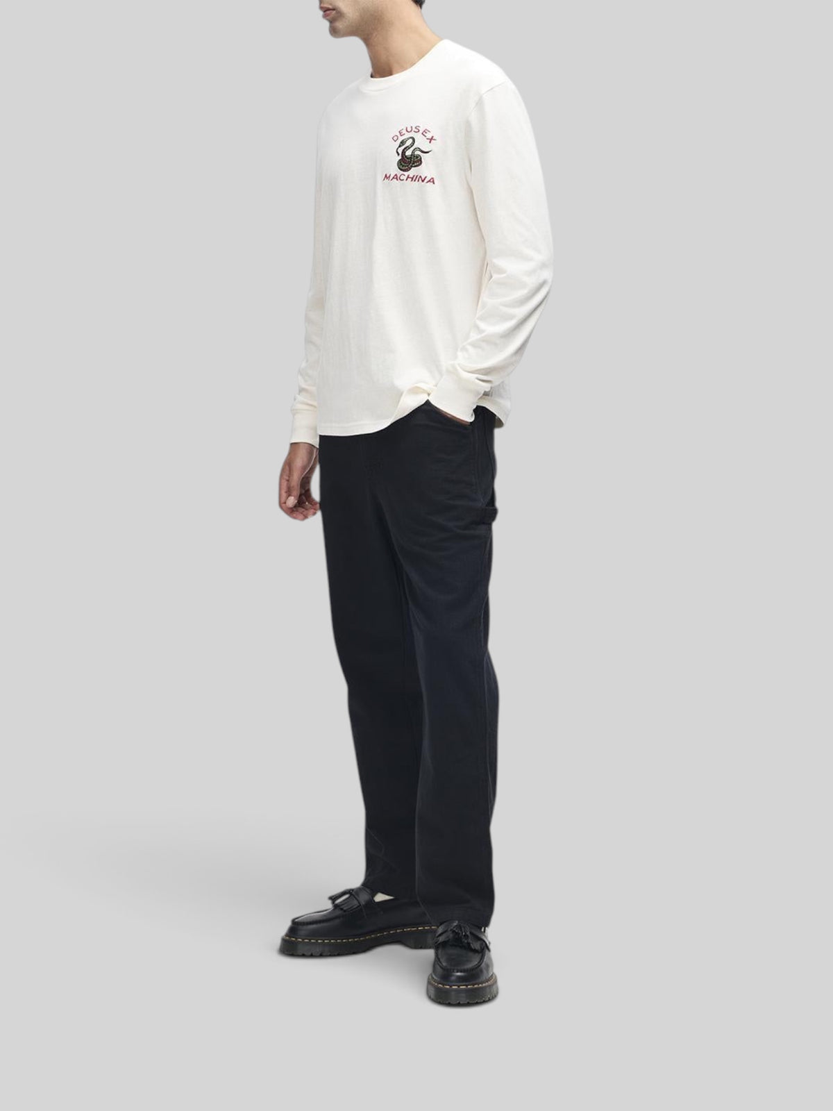 Baffle Haus Danger Noodle long sleeve tee in dirty white with chest embroidery, worn with black trousers.