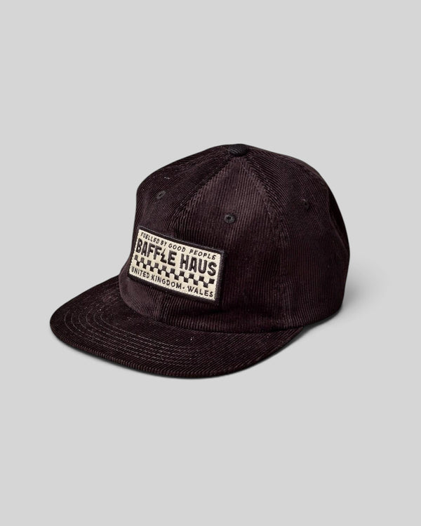 Baffle Haus dark brown corduroy panel cap with a rectangular logo patch on the front