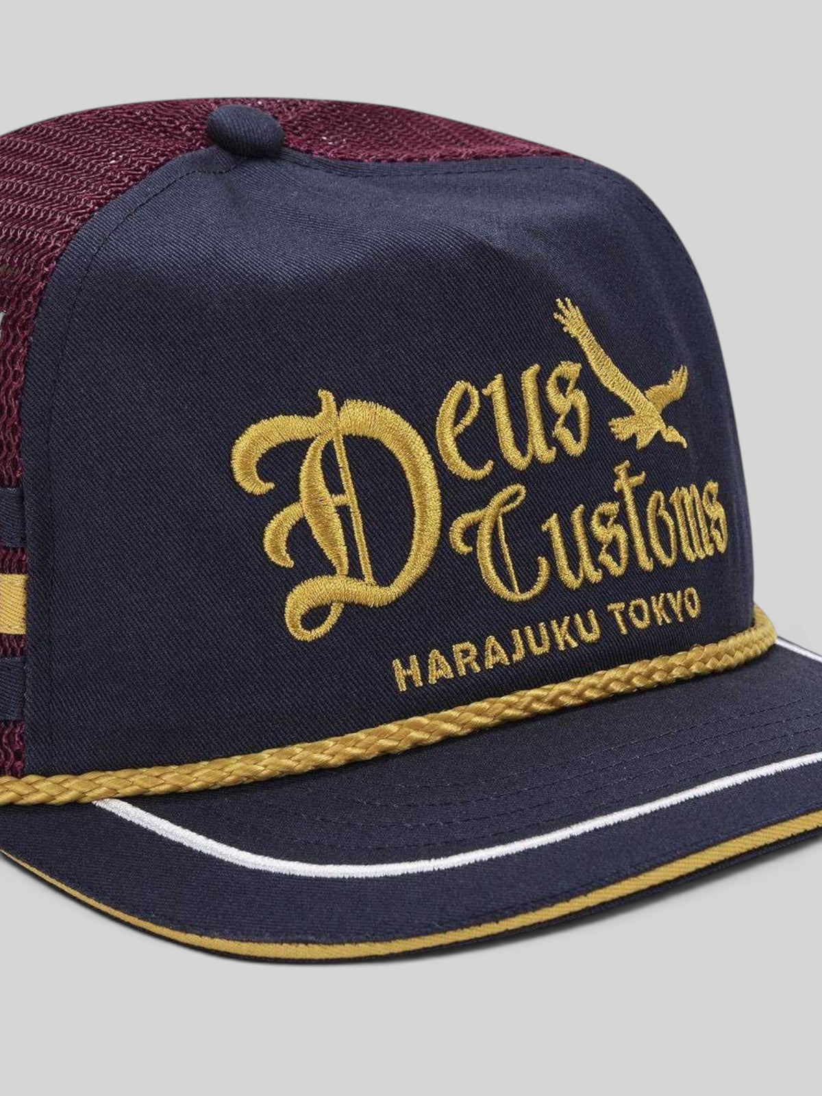 Baffle Haus Beep-Beep trucker hat in dark navy cotton twill with gold Deus Customs embroidery and decorative rope trim
