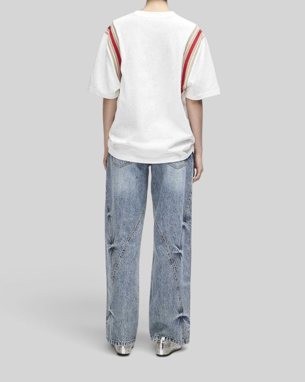 Baffle Haus Debute Tee in antique white with striped rib sleeve inserts, worn by a model from the back view.