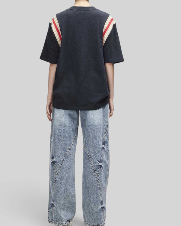 Baffle Haus Debute Tee in black with striped rib sleeve inserts, worn in a relaxed oversized fit from the back view.
